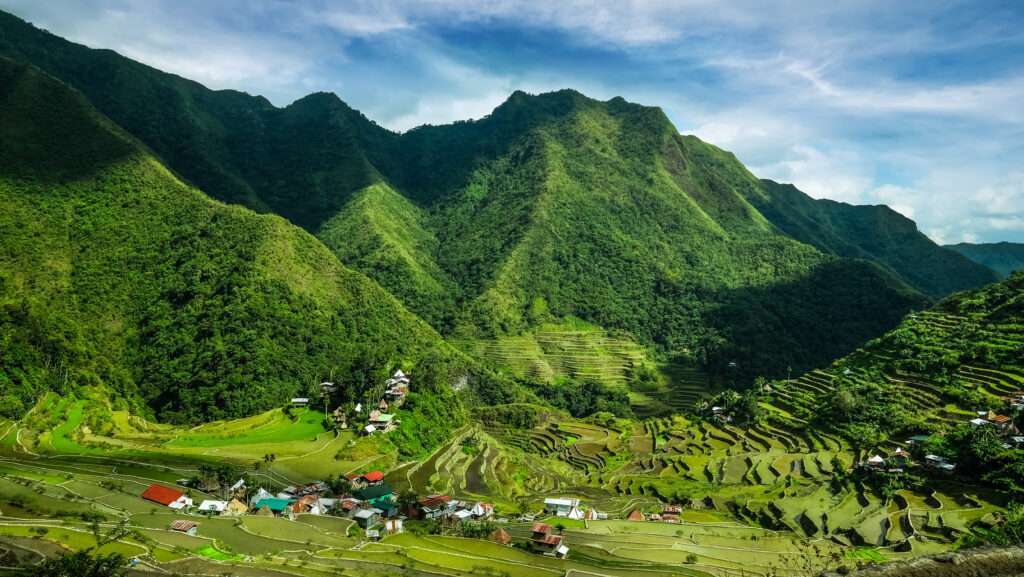 Village houses near rice terraces fields. Amazing abstract texture with sky colorful reflection in water. Ifugao province. Banaue, Philippines UNESCO heritage